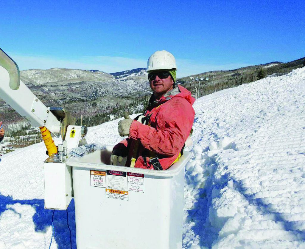 Donnie Kuntz of Current Electric in a bucket-truck lift on a snowy Steamboat mountainside