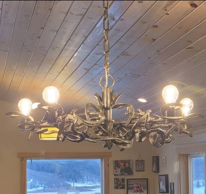 A custom horseshoe chandelier installed under a wood-plank ceiling