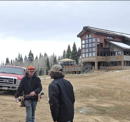Two Current Electric workers outside the Rendezvous lodge at Steamboat Resort