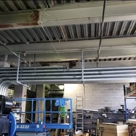 Metal conduit running overhead along a commercial building ceiling